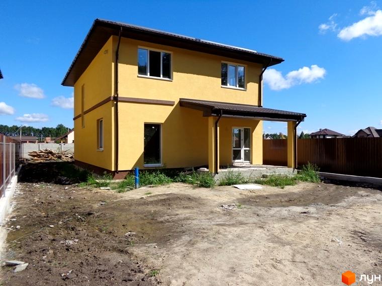 Фото будинку в Котеджному містечку Village-Мархалівка. Двоповерховий будинок жовтого кольору з коричневим дахом та вікнами, прибудинкова територія.