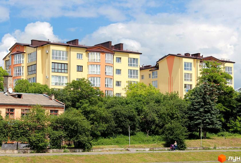 Зображення будинку на вул. Юрія Руфа (Некрасова), 36. Житловий комплекс з великими вікнами та зеленими насадженнями навколо.