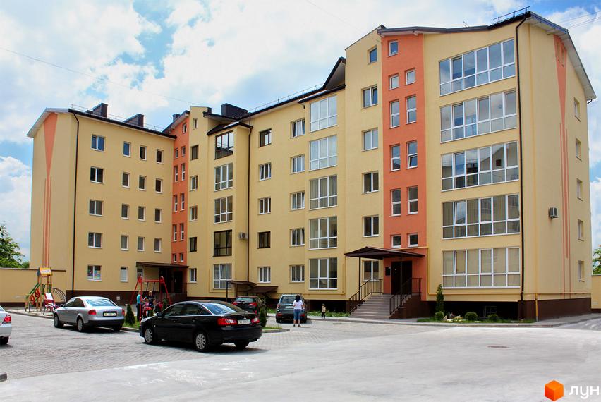 Зовнішній вигляд будинку на вулиці Юрія Руфа (Некрасова), 36. На прибудинковій території є парковка та дитячий майданчик.