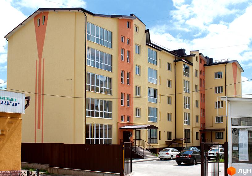 Зображення фасаду Житлового комплексу на вулиці Юрія Руфа (Некрасова), 36. Багатоповерхова будівля з великими вікнами та охайним подвір'ям.