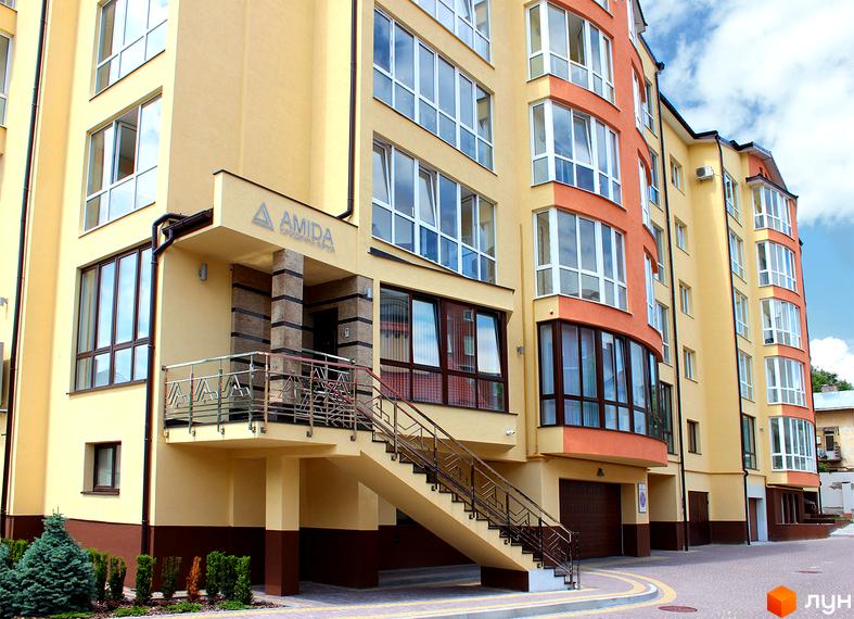 Зображення фасаду будинку за адресою вул. Юрія Руфа (Некрасова), 36. Житловий комплекс Amida з балконами та сходами на прибудинковій території.