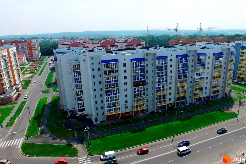 Житловий комплекс Мікрорайон „Поділля“ з сучасною архітектурою. Прибудинкова територія з зеленими насадженнями та автомобільними доріжками.