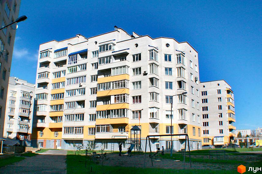 Зовнішній вигляд багатоквартирного будинку з жовтими елементами фасаду та дитячим майданчиком на прибудинковій території. Новобудова Мікрорайон „Поділля“.