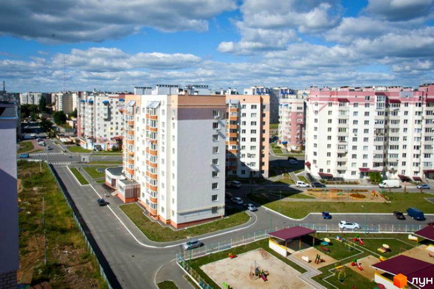 Житловий комплекс „Поділля“: багатоповерхові будинки з балконами та дитячі майданчики на прибудинковій території.