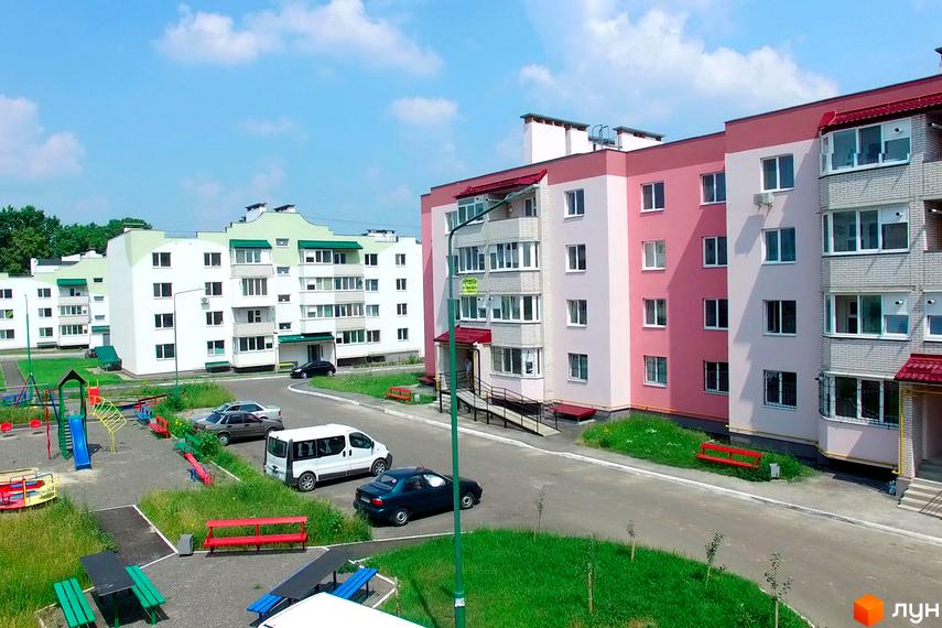 Житловий комплекс Мікрорайон „Академічний“ з кольоровими фасадами та прибудинковою територією, обладнаною дитячим майданчиком.
