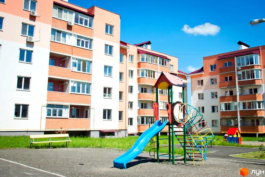 Житловий комплекс Мікрорайон „Академічний“ з яскравими фасадами та прибудинковою територією, де розташовані дитячі ігрові елементи.
