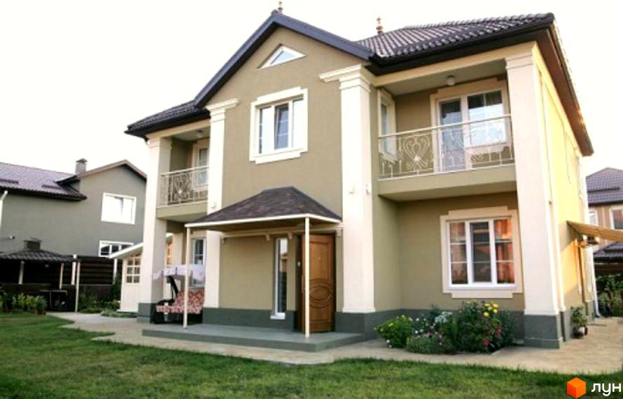 Зображення двоповерхового будинку в Котеджному містечку Family House. Навколо будинку зелений газон та клумби з квітами.
