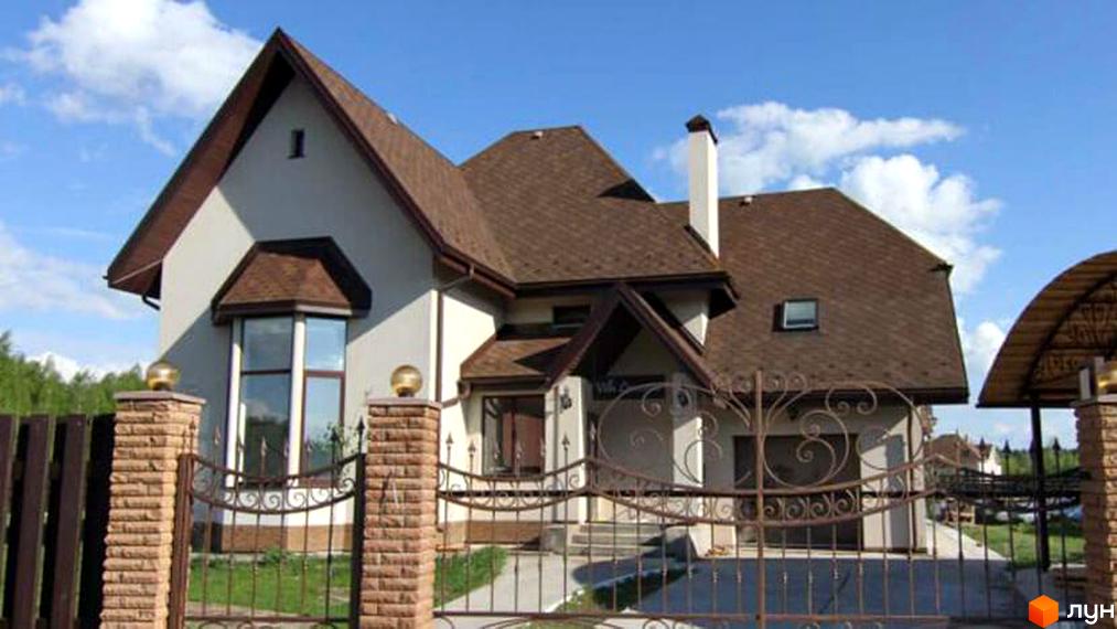 Котеджний комплекс Swiss Village з будинками з коричневою черепицею та білими стінами. На території є ковані ворота та цегляні стовпи.
