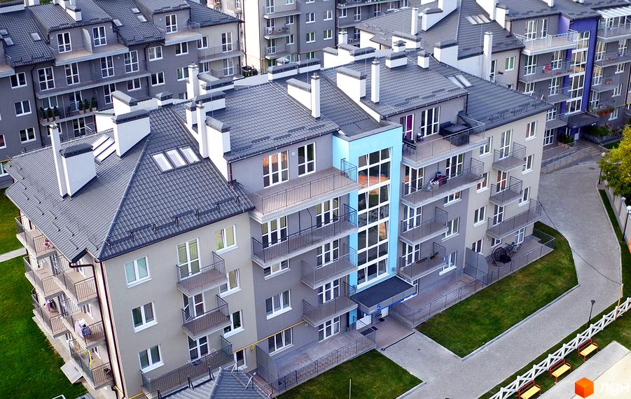 Зображення Житлового комплексу Бельгійське містечко. Багатоповерхові будинки з балконами та сірими дахами, зелена прибудинкова територія.