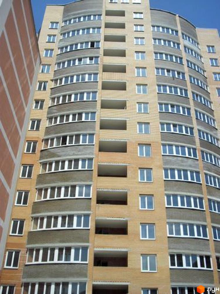 Фасад житлового комплексу на вул. Леваневського, 70, з численними вікнами та балконами. Будинок має цегляний вигляд та сірі декоративні елементи.