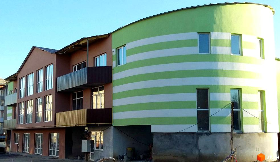 Зовнішній вигляд Житлового комплексу Фамільний двір. Багатоповерховий будинок з балконами та оригінальним фасадом у смужку.