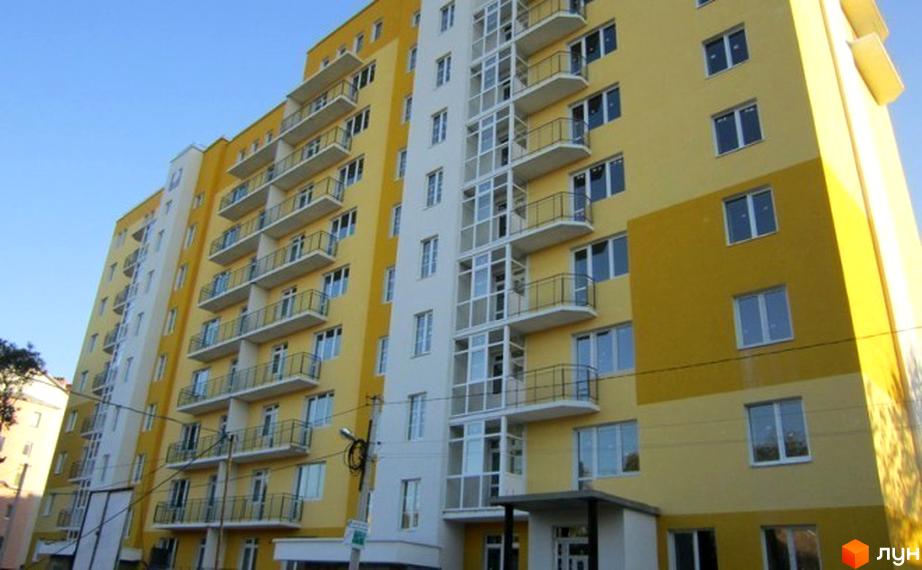 Новобудова на вул. Каховська, 27. Будинок має жовто-білий фасад, балкони та великі вікна.