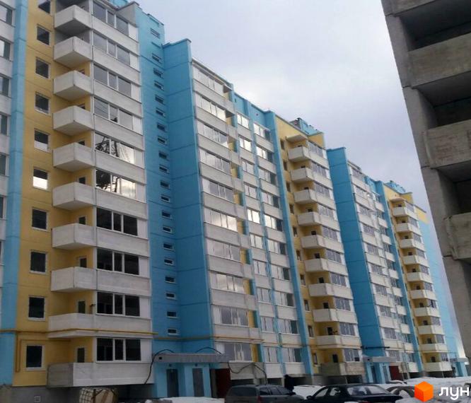 Житловий комплекс на вулиці Параджанова, 3. Багатоповерховий будинок з балконами та вікнами, жовто-блакитного кольору. Навколо будинку видно автомобілі та вхід до під'їзду.