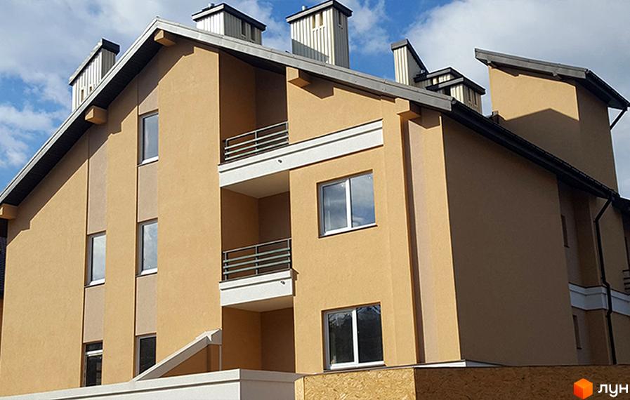 Фасад житлового комплексу Comfort Club з балконами та вікнами. Будинок має бежевий колір та сучасний дизайн.