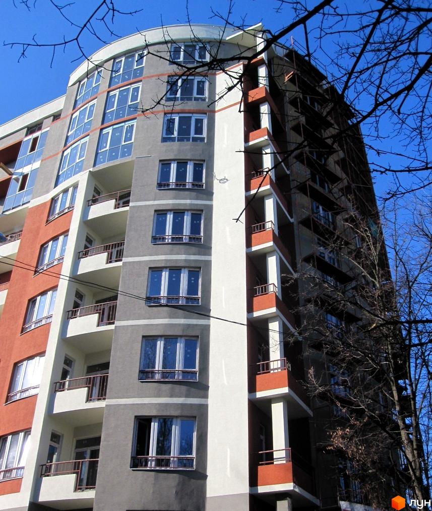 Новобудова на вул. Кримська, 107: багатоповерховий житловий будинок з сіро-теракотовим фасадом, округлими балконами та великими вікнами.