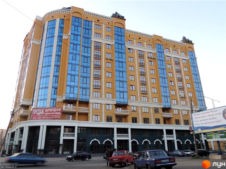 Житловий комплекс на вулиці Івана Банка (Коваля), 2 – це багатоповерхова будівля з жовтим фасадом та великими синіми вікнами. Будинок має вигнуту форму та привабливий зовнішній вигляд. Навколо будівлі видно автомобілі та тротуар.