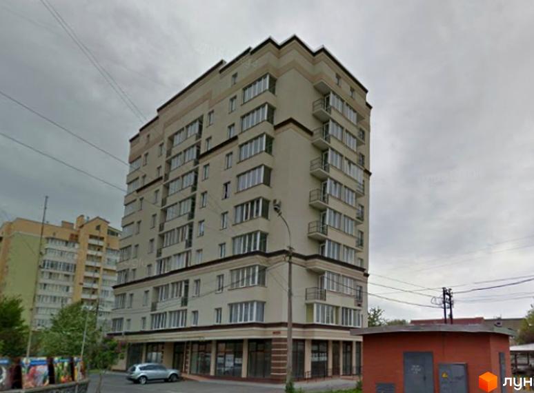 Багатоповерховий житловий будинок на вул. Клешканя, 11 з світлим фасадом, балконами та комерційними приміщеннями. Поруч припаркований автомобіль та технічна споруда.