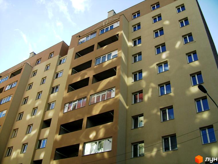 Новобудова на просп. Свободи (вул. Прокоф'єва), 16: фасад будівлі з бежевими та коричневими секціями, прямокутними вікнами та балконами.