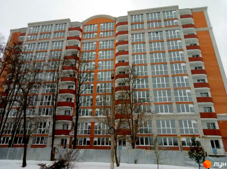 Зовнішній вигляд багатоповерхового будинку житлового комплексу на вул. Шевченка, 99а, 99б, 101а. Навколо будинку дерева та сніг на землі.