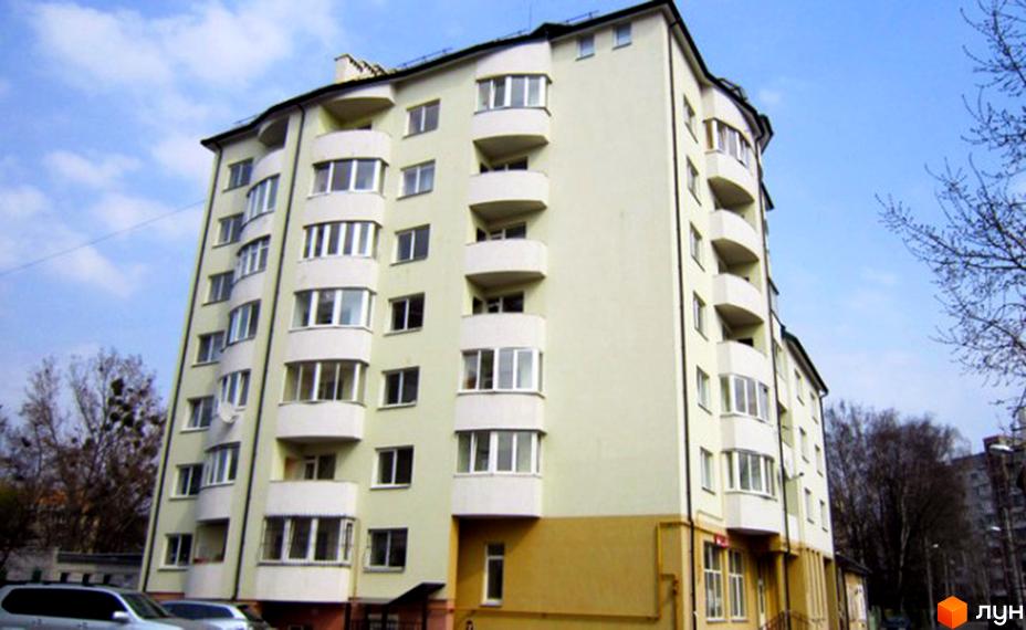 Житловий комплекс на вул. Бальзака, 33: світлий багатоповерховий будинок з коричневим цоколем та округлими балконами. Перед ним припарковані авто.