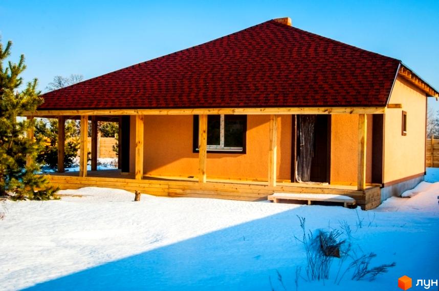 Будинок в Котеджному містечку HappyTown: одноповерховий, з червоним дахом та дерев'яною терасою, на засніженій ділянці.