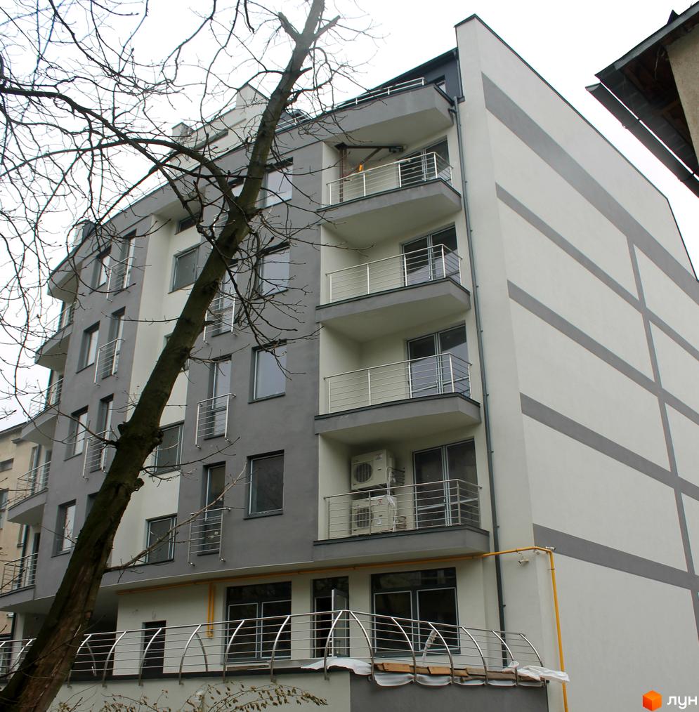 Зовнішній вигляд новобудови на вул. Глибока, 9-11. Багатоповерховий будинок з балконами та кондиціонерами. Навколо будівлі видно гілки дерев.