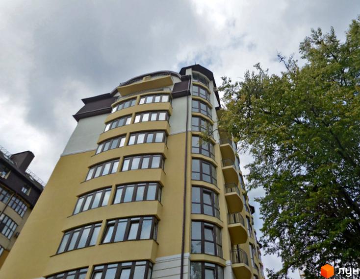 Житловий комплекс СУВОРОВА – фасади будівель з панорамними вікнами та балконами. Зелені дерева біля будинку під сірим небом.