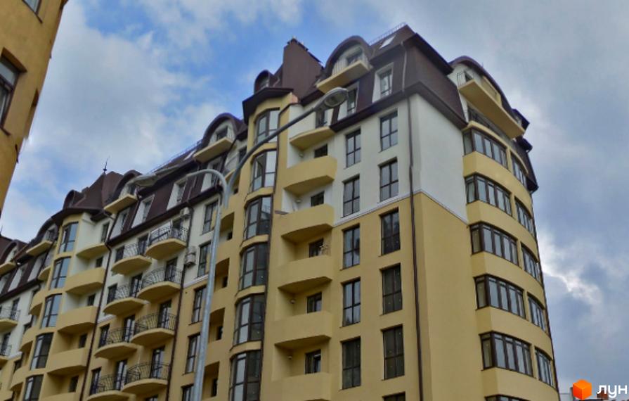 Зовнішній вигляд новобудови ЖК Суворова з білими та жовтими фасадами, балконами та темним дахом. Сучасна архітектура житлового комплексу.