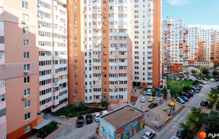 Житловий комплекс Райдужний - багатоповерхові будинки з балконами та кондиціонерами. Прибудинкова територія з дитячим майданчиком та парковкою.