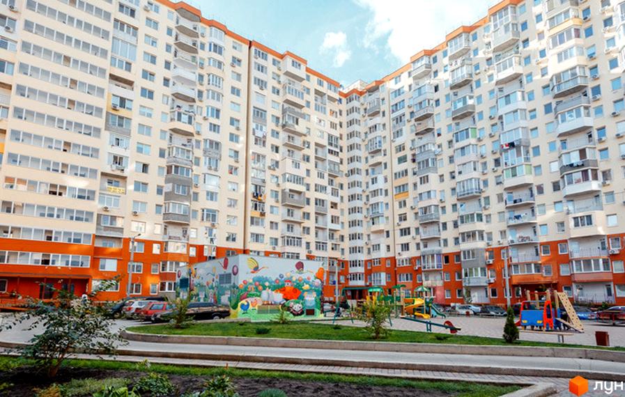 Житловий комплекс Райдужний: багатоповерхові будинки з балконами та кондиціонерами, дитячий майданчик та зелена зона біля будинку. Огляд новобудови.