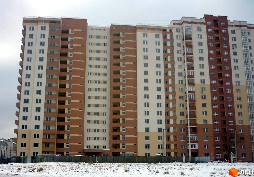 Новобудова на вулиці Панча, 18б: багатоповерховий будинок з бежево-коричневим фасадом. Перед ним засніжена ділянка.