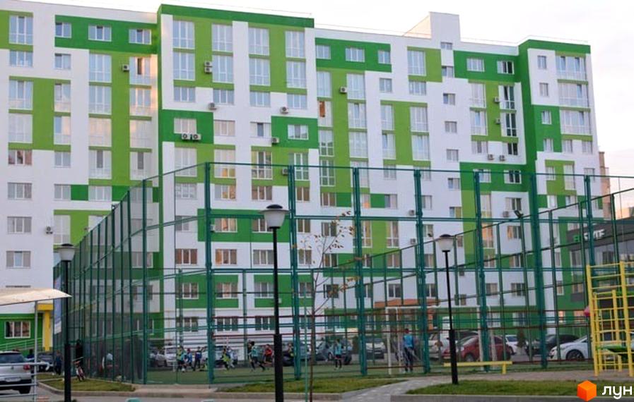 Житловий комплекс ЖМ Острови з яскравим фасадом, прибудинкова територія з спортивними майданчиками та зеленими зонами.