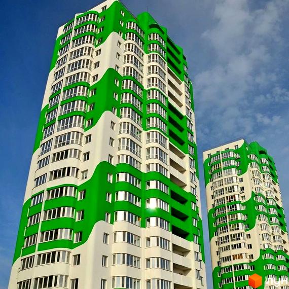 Житловий комплекс ЖМ Острови з яскравою зеленою фасадною обробкою та великими вікнами. Прибудинкова територія облаштована для комфортного відпочинку.