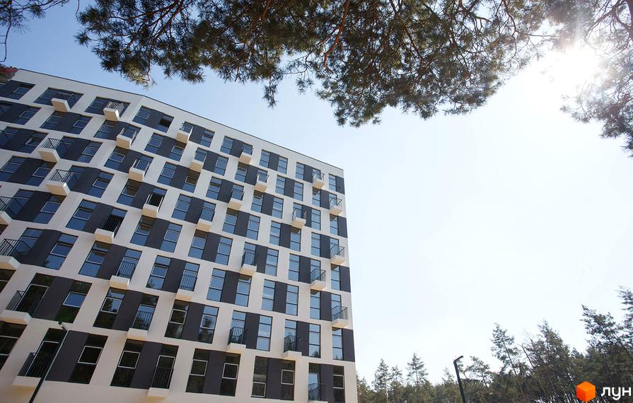 Житловий комплекс Park Town з великою кількістю вікон та балконів. Навколо будинку ростуть дерева, що створюють приємну атмосферу.