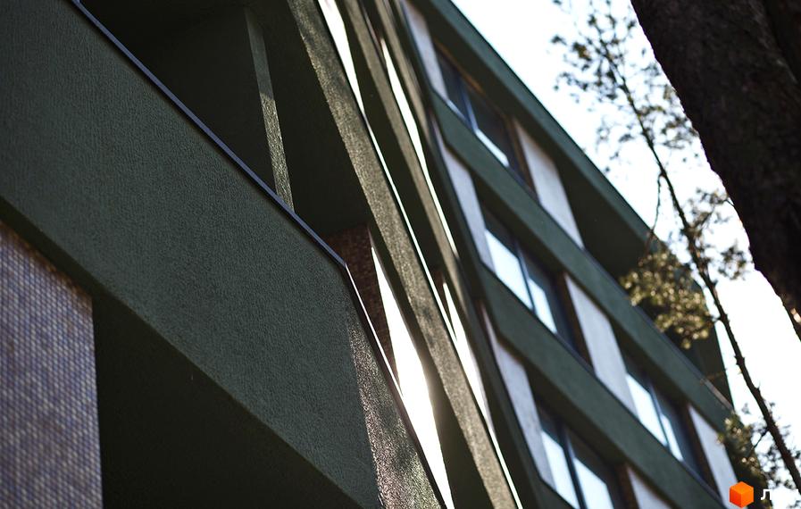 Житловий комплекс Park Town з фасадом у зелених тонах. Архітектура будівлі з чіткими лініями та великими вікнами.