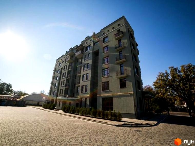 Клубний будинок Парковий. Зовнішній вигляд будівлі з балконами та вікнами, прибудинкова територія з бруківкою та деревами.