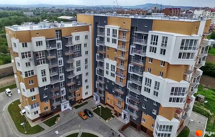 Житловий комплекс Галактика: багатоповерховий будинок з контрастним фасадом, балконами. Прибудинкова територія з доріжками, зеленню та парковкою.