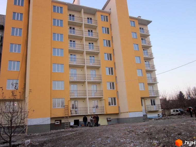 Житловий комплекс Садовий – сучасна новобудова з жовтим фасадом та балконами. Навколо будинку облаштована прибудинкова територія.