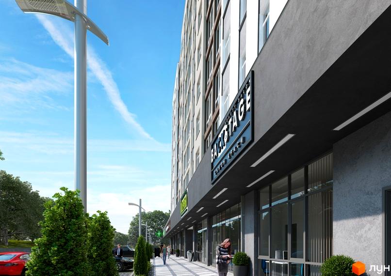 Новобудова ЖК IL Patio з фасадом з сірого каменю та великими вікнами. Поруч розташована доглянута прибудинкова територія з деревами та пішохідною зоною.