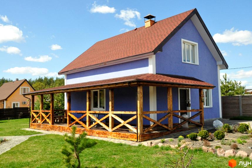 Будинок Котеджного містечка HappyTown з фіолетовими стінами, коричневим дахом та дерев'яною верандою. Навколо зелений газон.