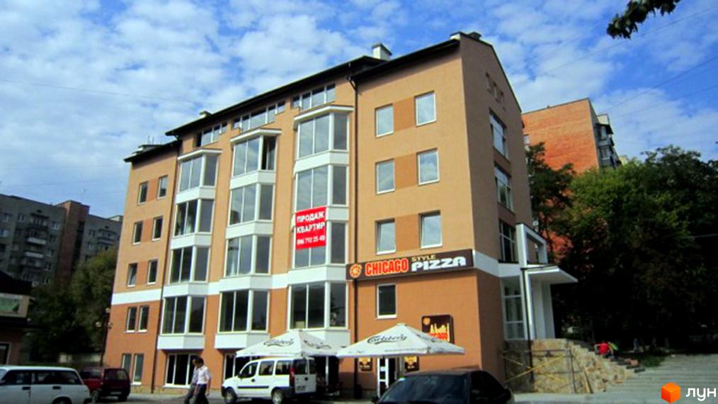 Новобудова на вулиці Мазепи, 11г. Багатоповерховий будинок з балконами та вікнами, поруч розташовані парасолі та вивіска 