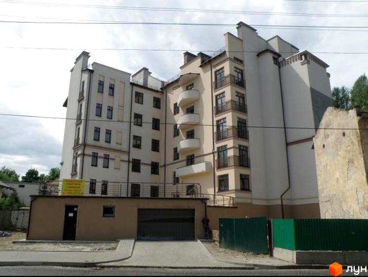 Будівельний проєкт на вул. Левицького, 128. Багатоповерховий будинок світло-бежевого кольору з балконами та прибудинковою територією з зеленим парканом та гаражем.