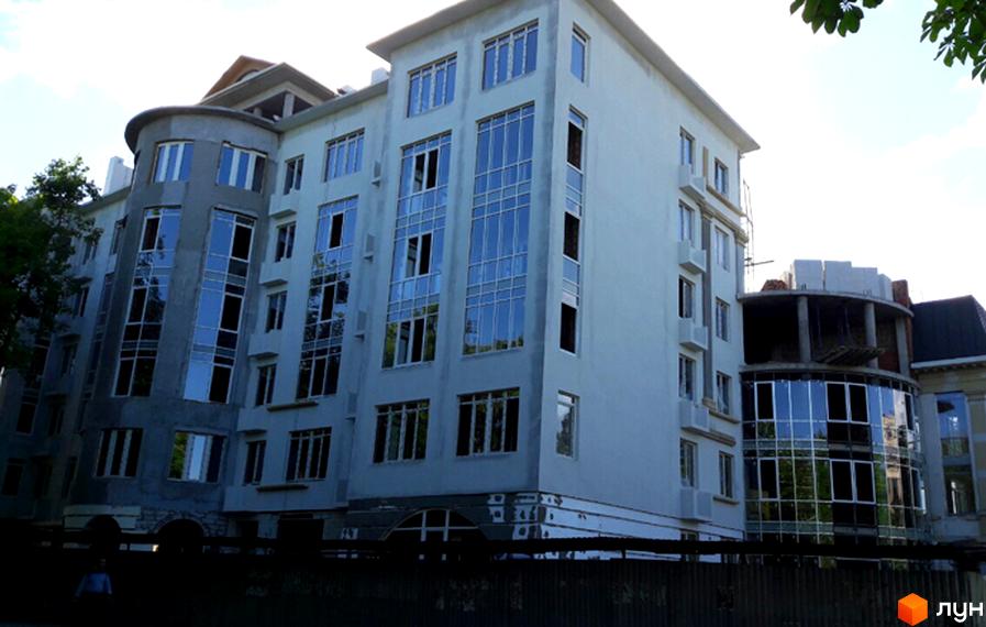 Зовнішній вигляд житлового комплексу Парковий. Будівля має багато вікон та сучасну архітектуру. Навколо видно зелені насадження та паркан.