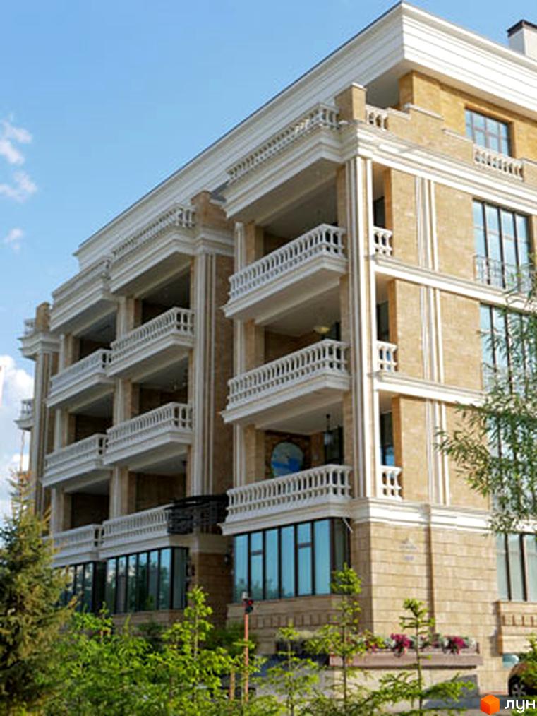 Житловий комплекс Liberty Estate з балконами та скляними вікнами. На передньому плані зелені дерева та кущі.