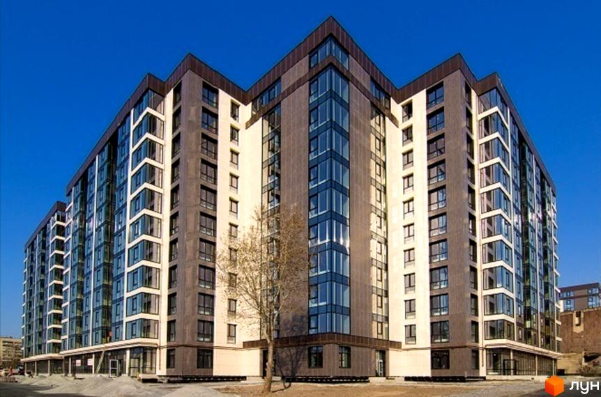 Фасад новобудови Житловий комплекс Салют складається зі світлих та темних панелей, доповнений великими вікнами. Перед будинком ростуть дерева.