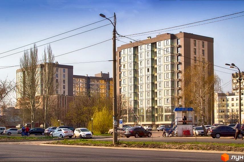 Новобудова ЖК Салют з великою кількістю вікон та парковкою перед будинком. Навколо розташовані дерева та дорога.
