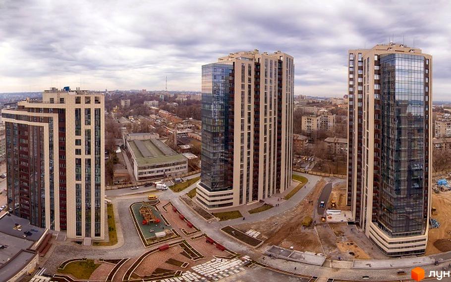 Високоповерхові будинки ЖК Панорама з панорамним склінням. На прибудинковій території розташований дитячий майданчик та пішохідні доріжки.