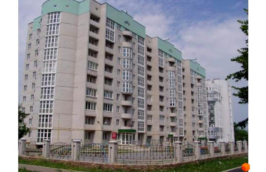 Житловий комплекс Банківський з фасадом з великими вікнами та зеленою покрівлею. Прибудинкова територія огороджена, з газонами та доріжками.