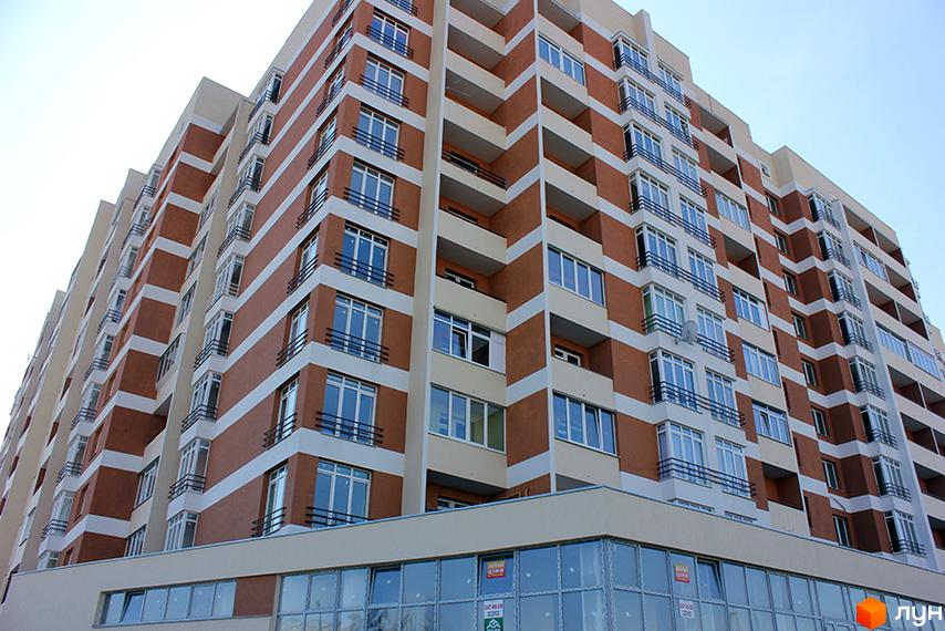 Будинок житлового комплексу на вул. Перфецького, 2а. Фасад будівлі оздоблений коричневою та білою плиткою, з численними вікнами та балконами.