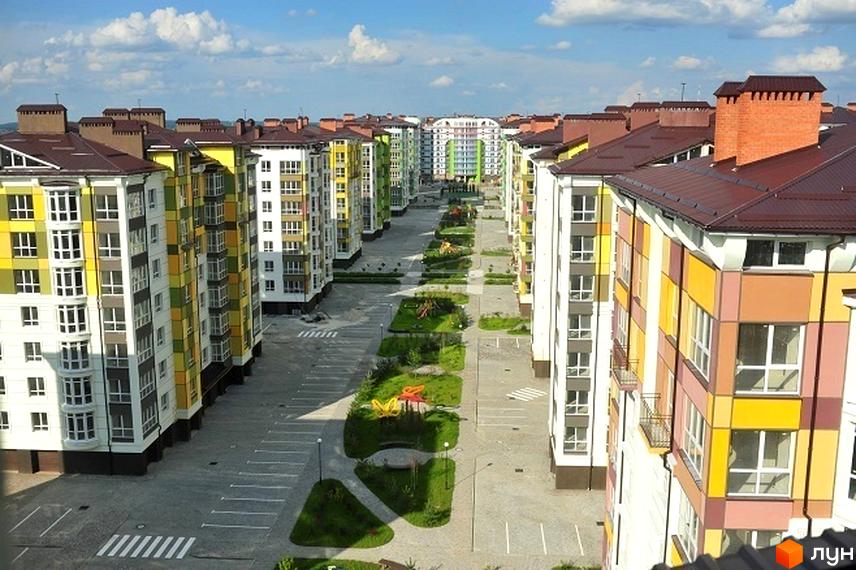 Зображення Житлового комплексу Калинова Слобода. Вид на різнокольорові будинки та облаштовану прибудинкову територію з дитячими майданчиками.